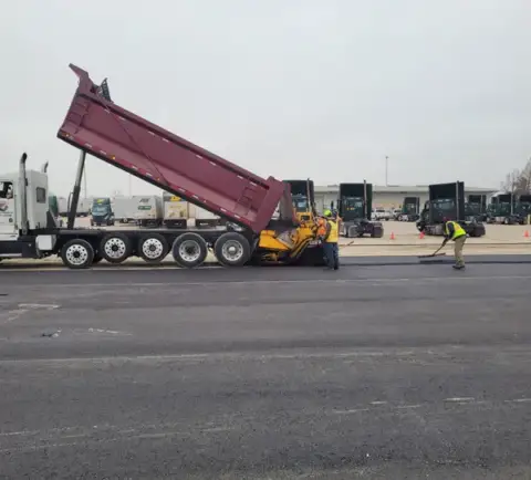 A large truck working on paving project.